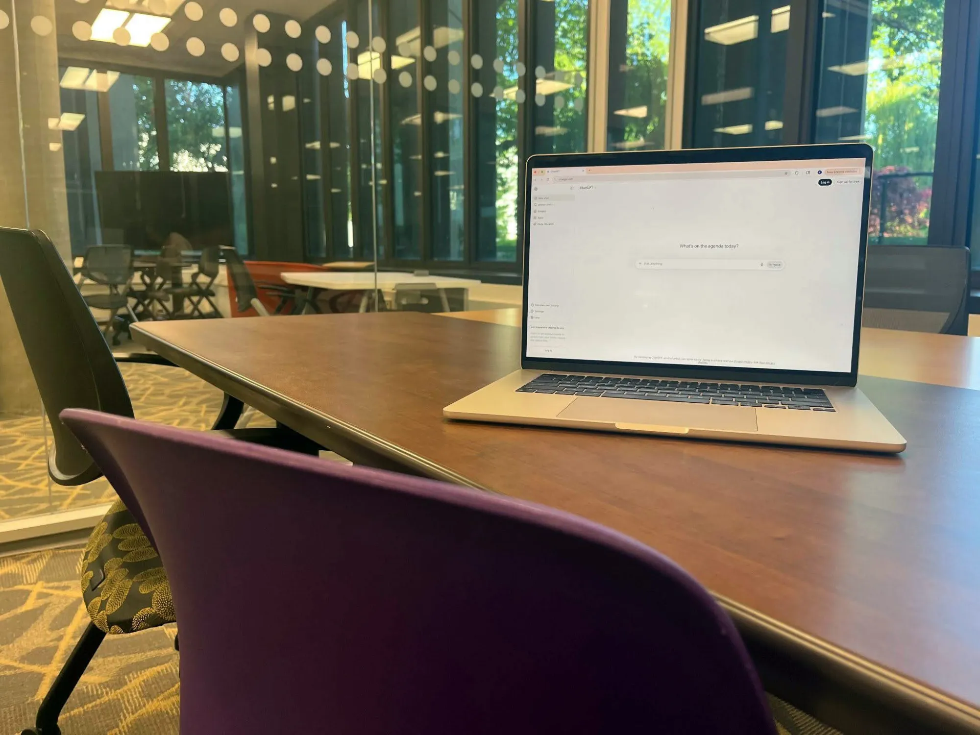 laptop with ChatGPT on the screen sitting on a table in a library